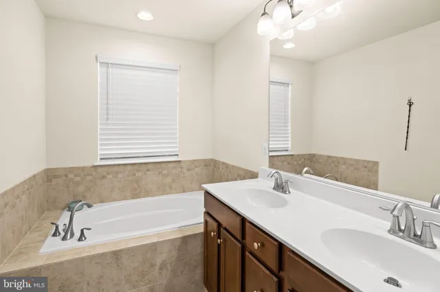 a bathroom with a tub sink and mirror