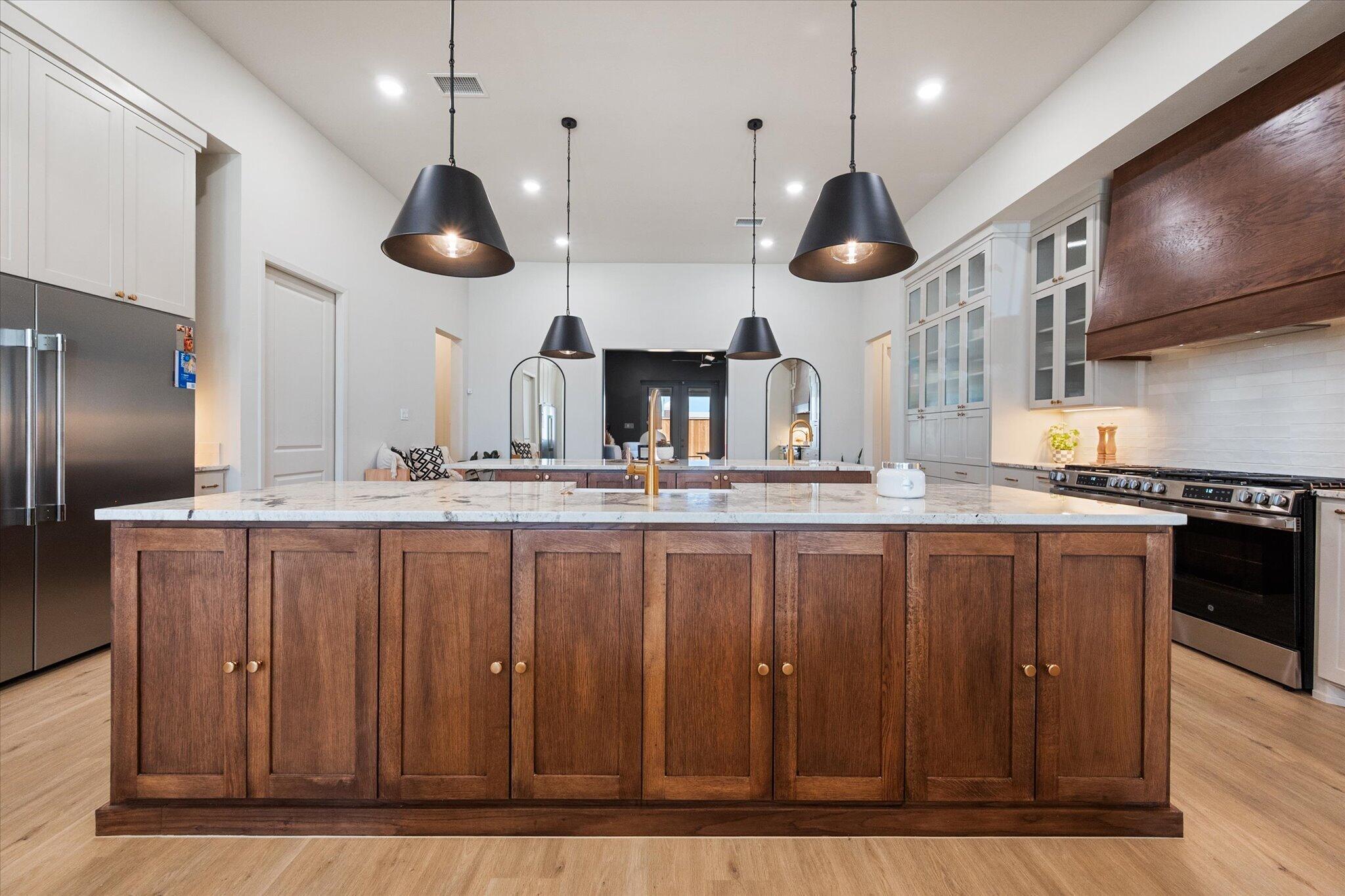 4026 136th Street Lubbock, TX 79423 - Photo 7 of 40 a kitchen with stainless steel appliances granite countertop a stove a sink and a wooden floor