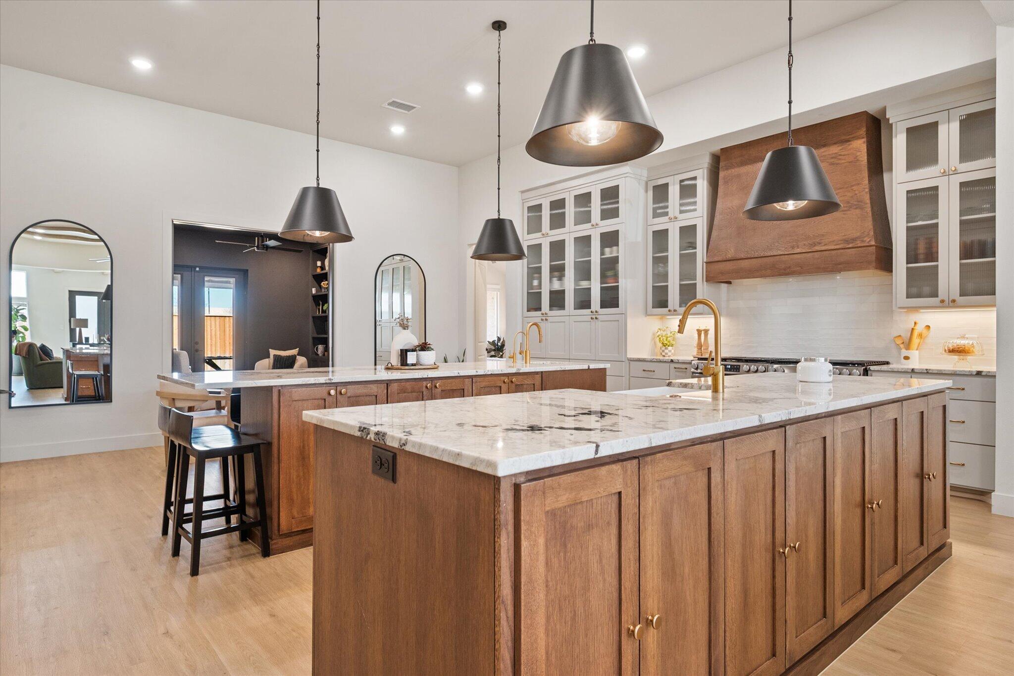 4026 136th Street Lubbock, TX 79423 - Photo 8 of 40 a kitchen with cabinets a sink a counter and chairs in it