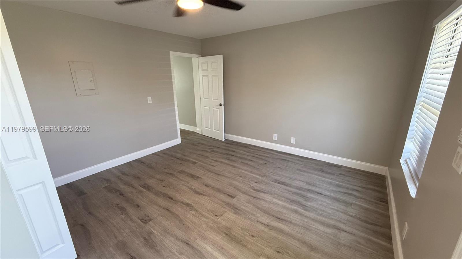 220 Northwest 12th Street, Unit 14 Pompano Beach, FL 33060 - Photo 14 of 19 an empty room with wooden floor and windows
