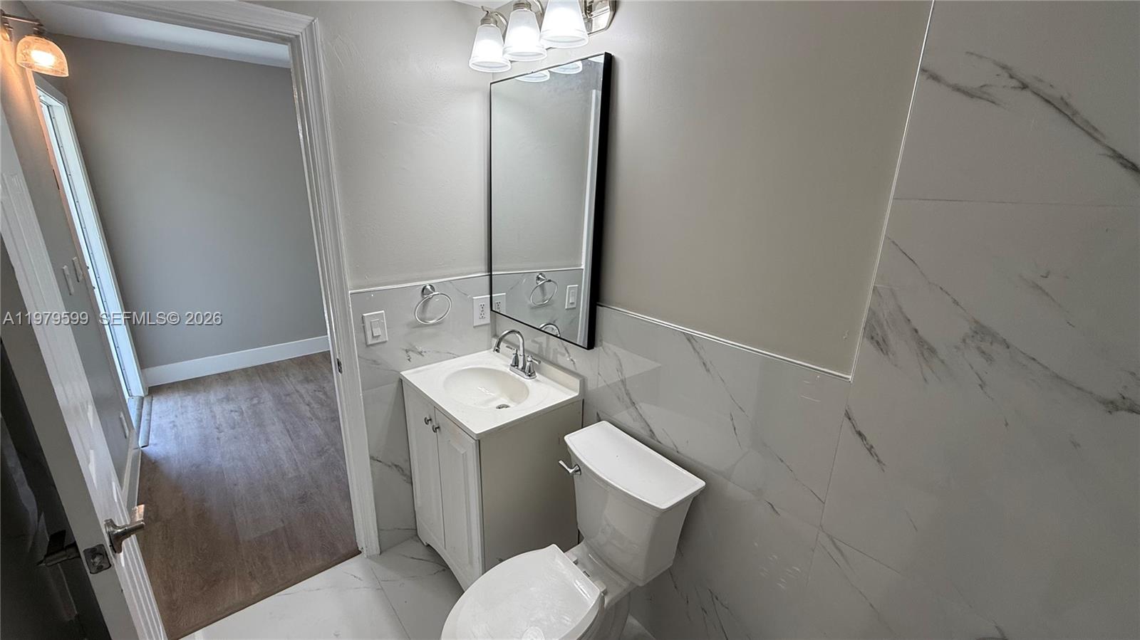 220 Northwest 12th Street, Unit 14 Pompano Beach, FL 33060 - Photo 19 of 19 a bathroom with a sink toilet and mirror