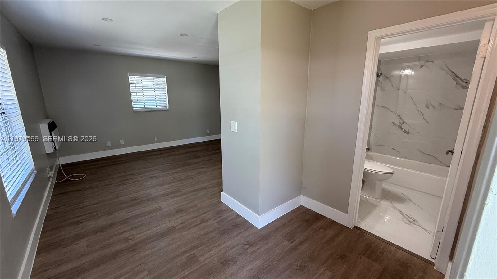 220 Northwest 12th Street, Unit 14 Pompano Beach, FL 33060 - Photo 4 of 19 an empty room with wooden floor and windows