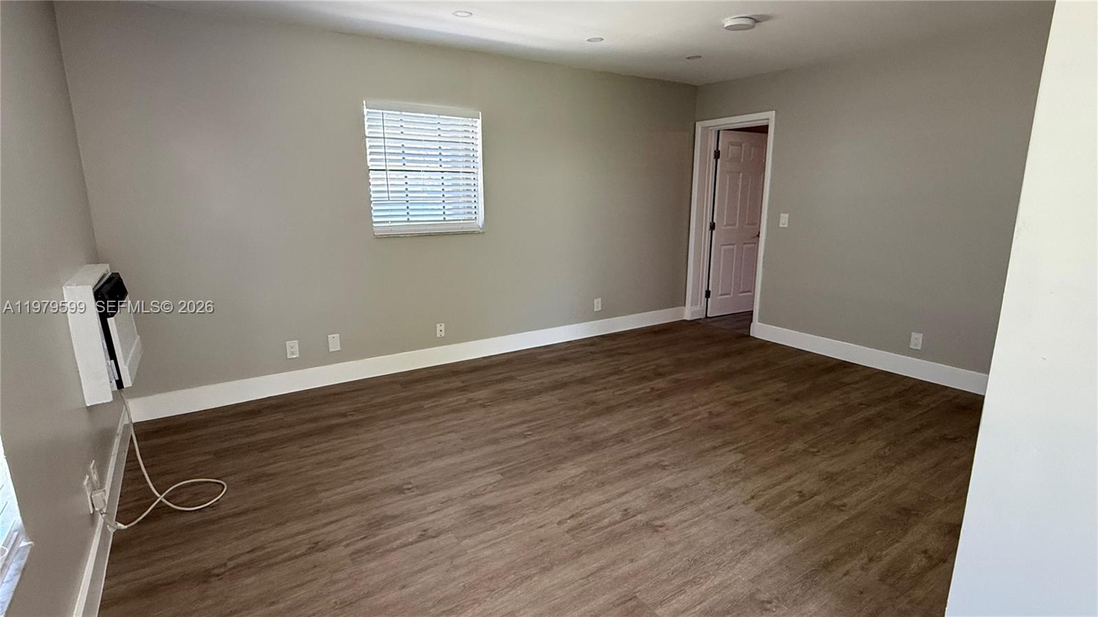 220 Northwest 12th Street, Unit 14 Pompano Beach, FL 33060 - Photo 5 of 19 an empty room with wooden floor and windows