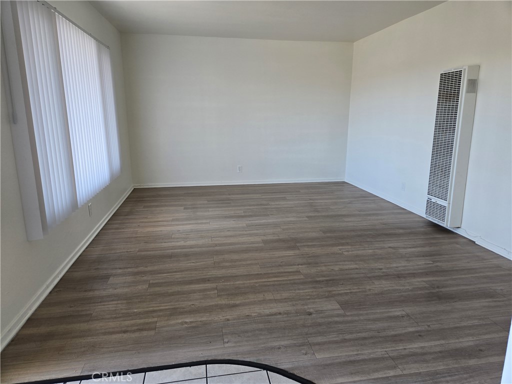 1834 Pine Avenue, Unit 5 Long Beach, CA 90806 - Photo 3 of 11 a view of an empty room with wooden floor and a window