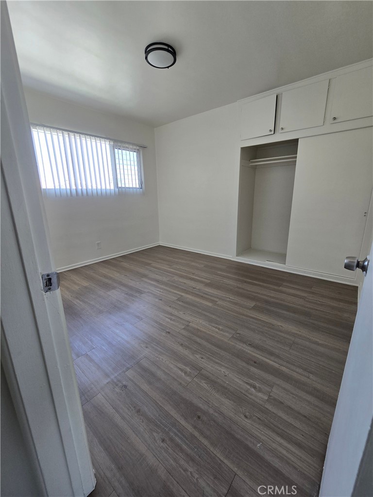 1834 Pine Avenue, Unit 5 Long Beach, CA 90806 - Photo 7 of 11 an empty room with wooden floor and windows