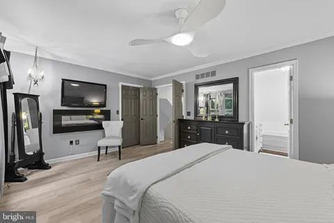 a bedroom with a bed and a flat tv screen on dresser