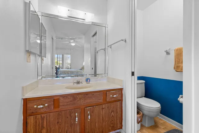 a bathroom with a sink a toilet a mirror and shower