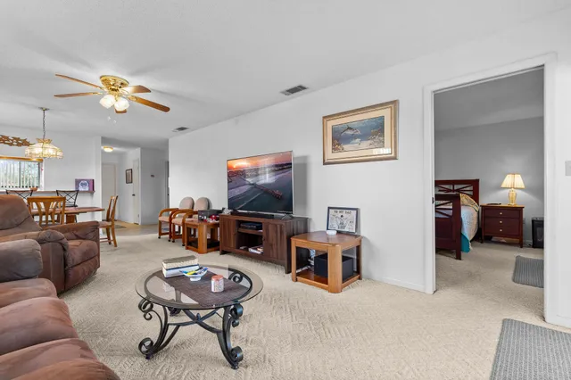 a living room with furniture a flat screen tv and a table