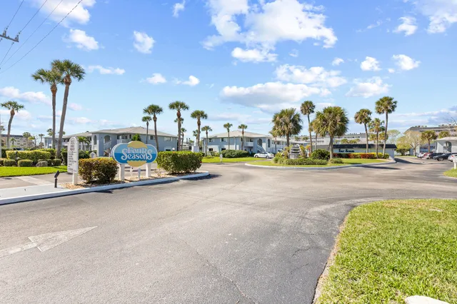 a view of a house with a yard and potted plants