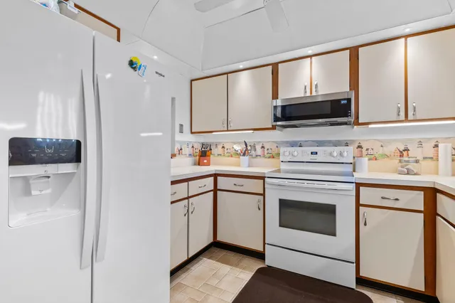 a kitchen with white cabinets and white appliances