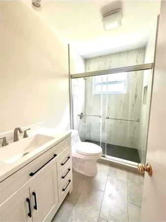 a bathroom with a toilet a sink and shower