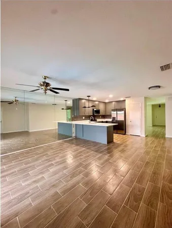 a view of kitchen and empty room with windows