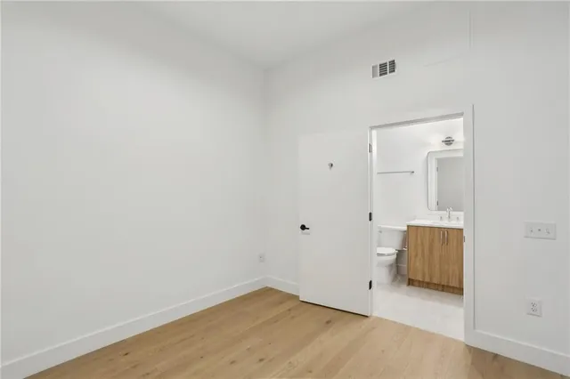 a view of room with wooden floor and mirror