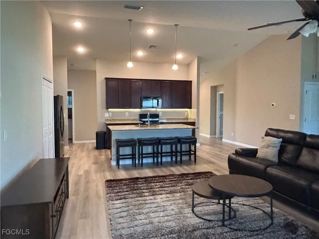 a bathroom with a granite countertop sink a mirror and a wooden cabinets