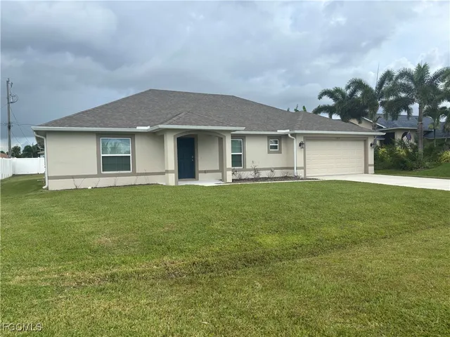 a front view of house with yard and garage