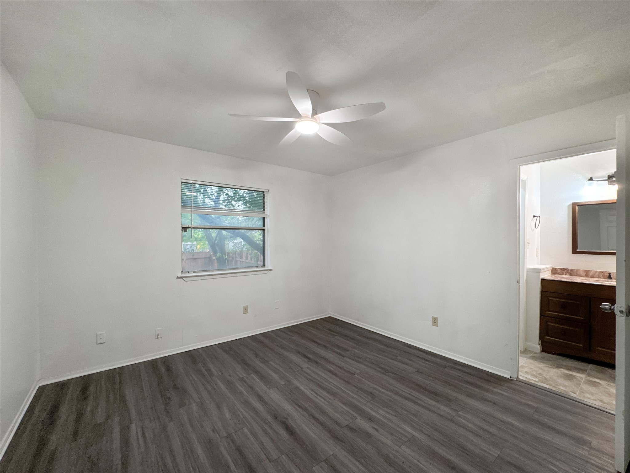 2017 Greenbrook Parkway, Unit B Austin, TX 78723 - Photo 11 of 14 Unfurnished bedroom featuring dark wood-type flooring, ceiling fan, and ensuite bathroom