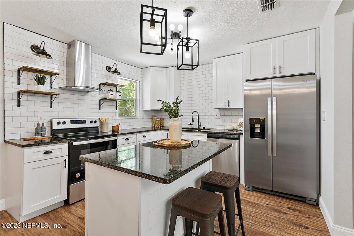 a kitchen with granite countertop a sink stove and refrigerator