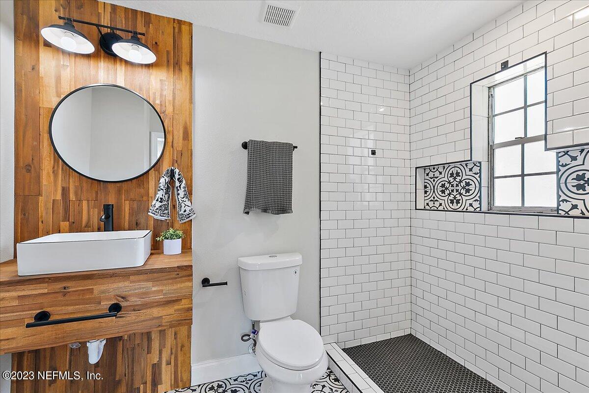 2435 Evernia Road Jacksonville, FL 32211 - Photo 8 of 15 a bathroom with a toilet a sink and a mirror