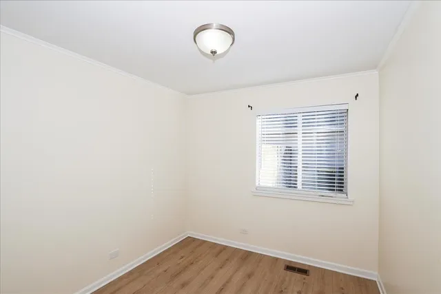 a view of a room with wooden floor and window