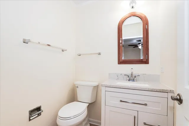 a bathroom with a toilet sink vanity and mirror