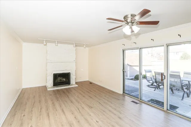 a view of an empty room with a fireplace and a window