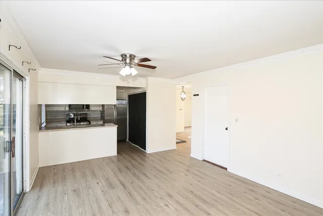 a living room with stainless steel appliances kitchen island hardwood floor and a window