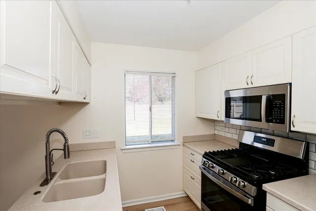 a kitchen with stainless steel appliances a stove a sink and a microwave