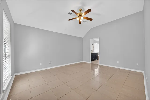 an empty room with a ceiling fan and a window