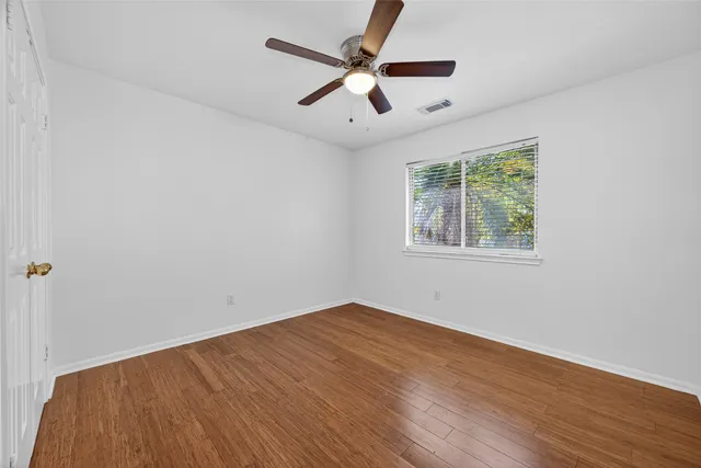 wooden floor in an empty room with a window