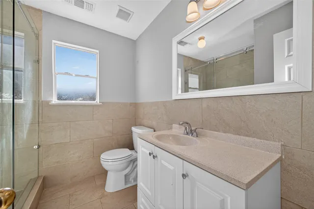 a bathroom with a granite countertop sink a toilet and a mirror