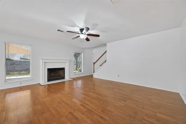 a view of an empty room with a fireplace and a window