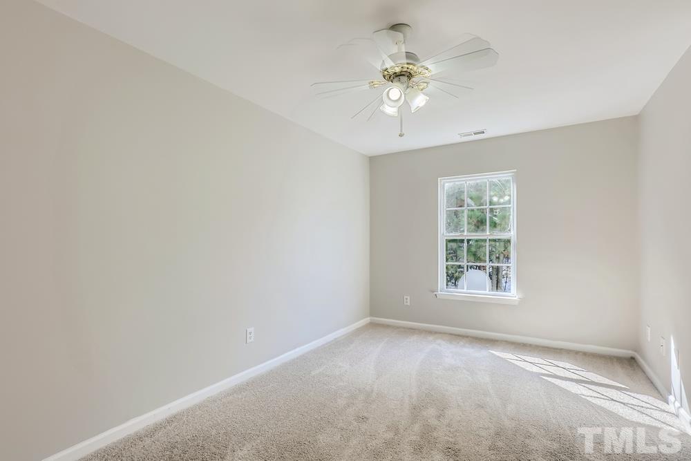 8610 Neuse Landing Lane, Unit 109 Raleigh, NC 27616 - Photo 12 of 28 an empty room with a chandelier fan and windows