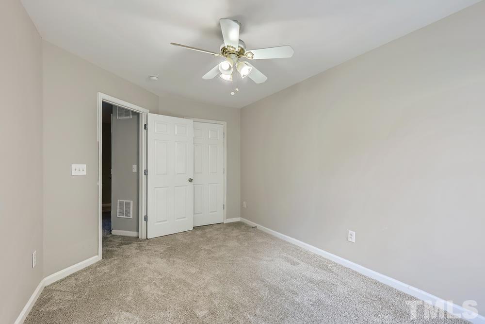 8610 Neuse Landing Lane, Unit 109 Raleigh, NC 27616 - Photo 15 of 28 an empty room with a ceiling fan and a window