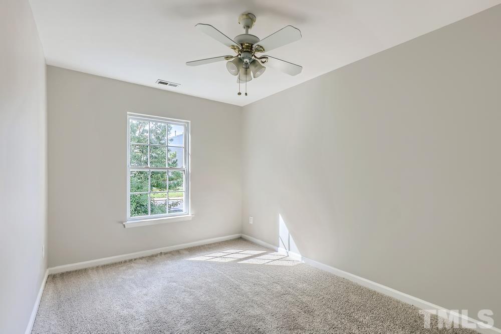 8610 Neuse Landing Lane, Unit 109 Raleigh, NC 27616 - Photo 16 of 28 an empty room with a window and a ceiling fan
