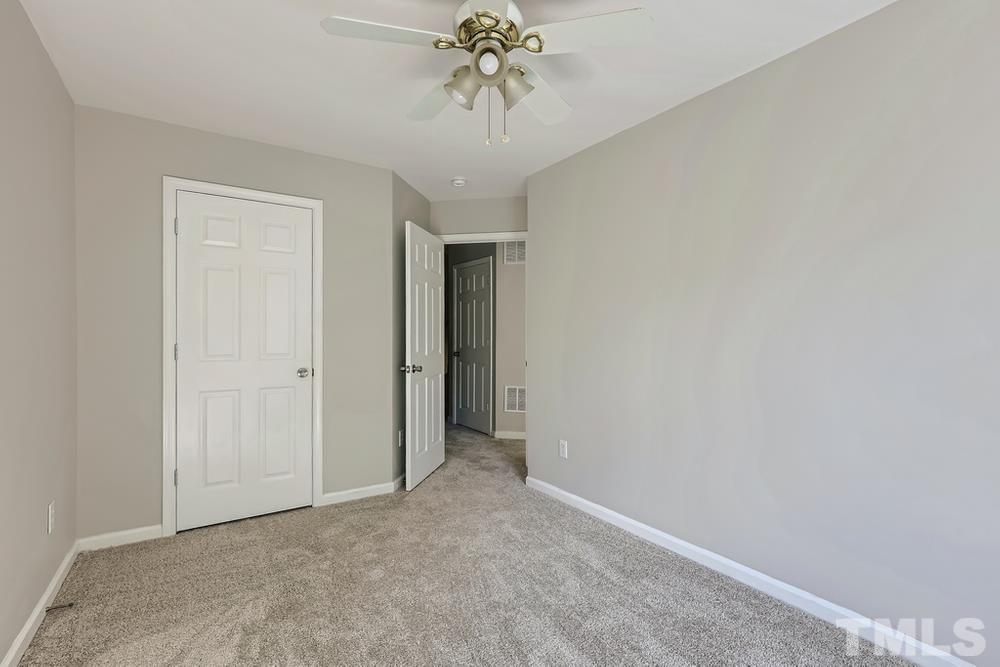 8610 Neuse Landing Lane, Unit 109 Raleigh, NC 27616 - Photo 18 of 28 an empty room with a chandelier fan and closet