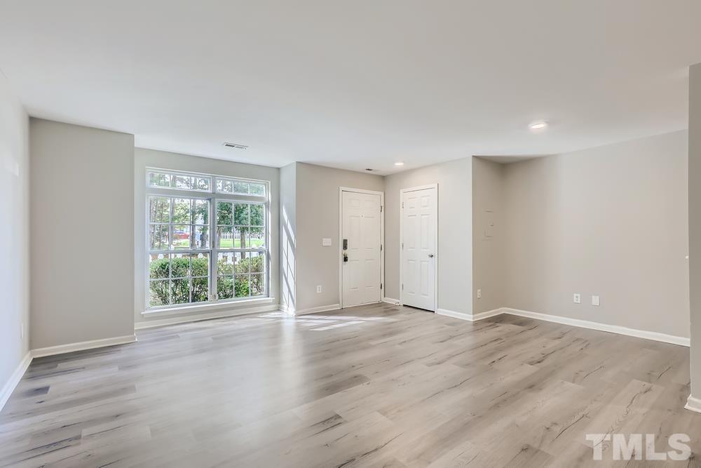 8610 Neuse Landing Lane, Unit 109 Raleigh, NC 27616 - Photo 6 of 28 a view of an empty room with wooden floor and a window