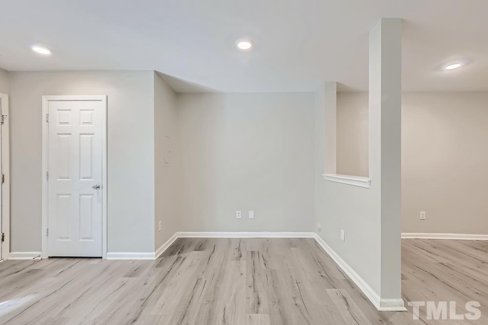 8610 Neuse Landing Lane, Unit 109 Raleigh, NC 27616 - Photo 8 of 28 a view of an empty room with wooden floor and a window