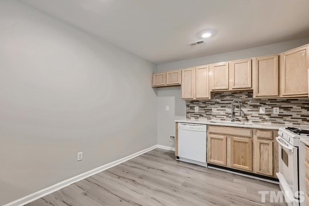 8610 Neuse Landing Lane, Unit 109 Raleigh, NC 27616 - Photo 9 of 28 a kitchen with granite countertop a sink cabinets and wooden floor