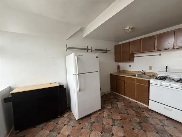 a utility room with dryer washer and empty racks