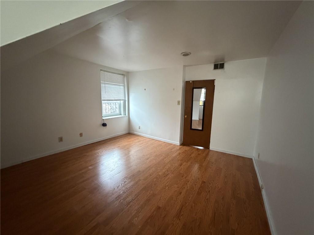 5807 Bartlett Street, Unit 5 Pittsburgh, PA 15217 - Photo 16 of 18 an empty room with wooden floor and windows