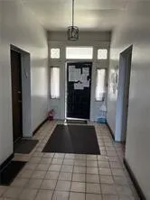 a view of a refrigerator in kitchen and a window
