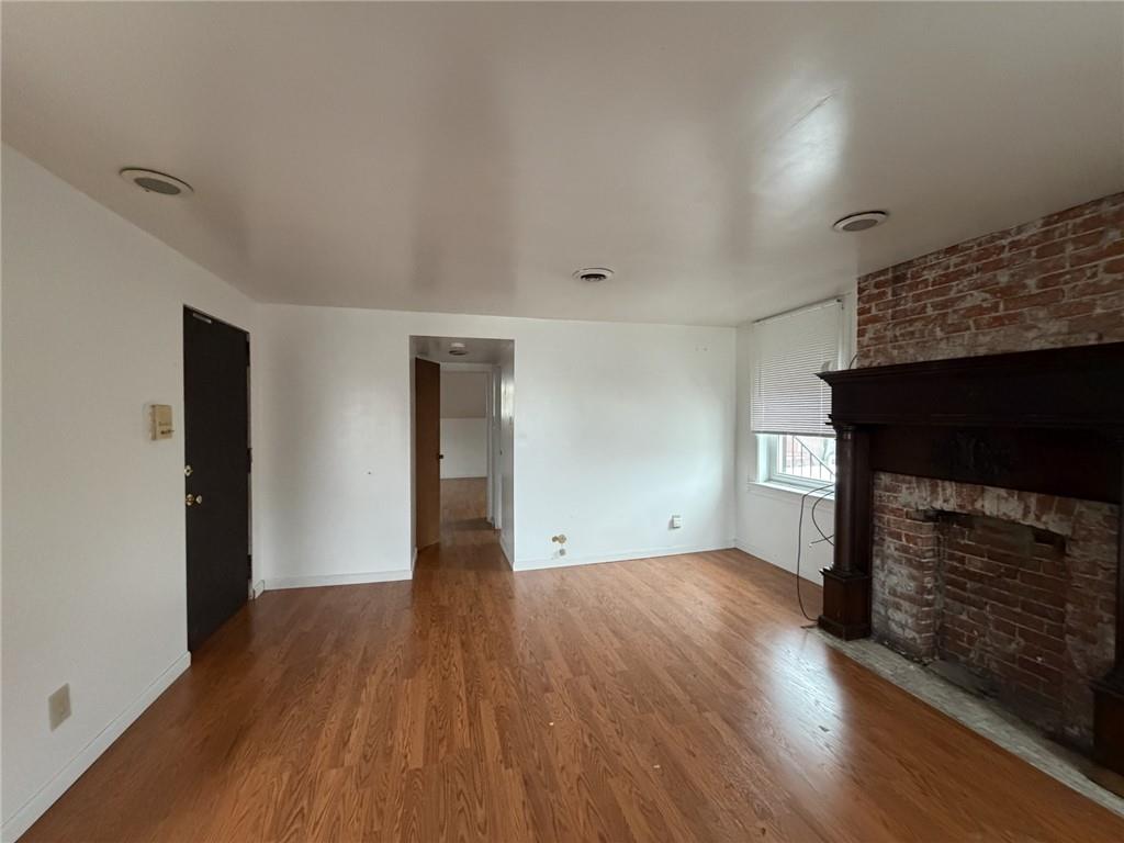 5807 Bartlett Street, Unit 5 Pittsburgh, PA 15217 - Photo 8 of 18 a view of empty room with wooden floor and fireplace