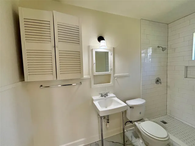a bathroom with a sink a toilet and shower