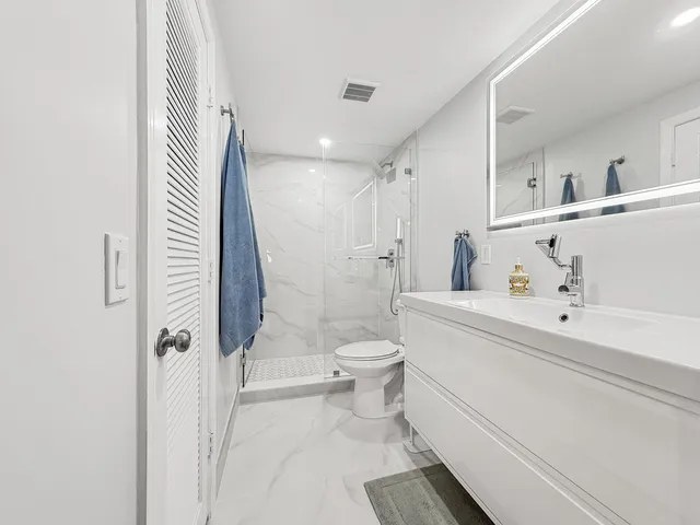 a bathroom with a sink a toilet and shower