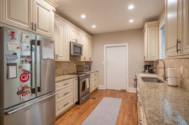 a kitchen with stainless steel appliances granite countertop a refrigerator and a sink