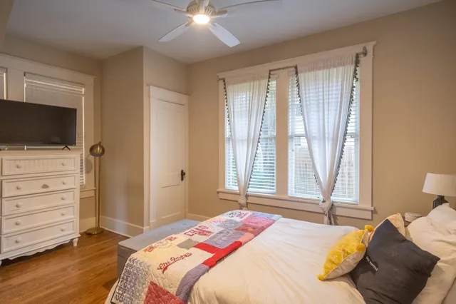 a bedroom with a bed and a flat tv screen on dresser