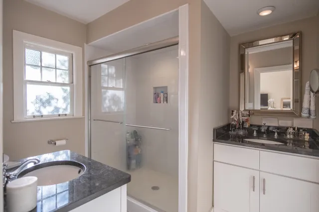a bathroom with a granite countertop sink toilet and shower