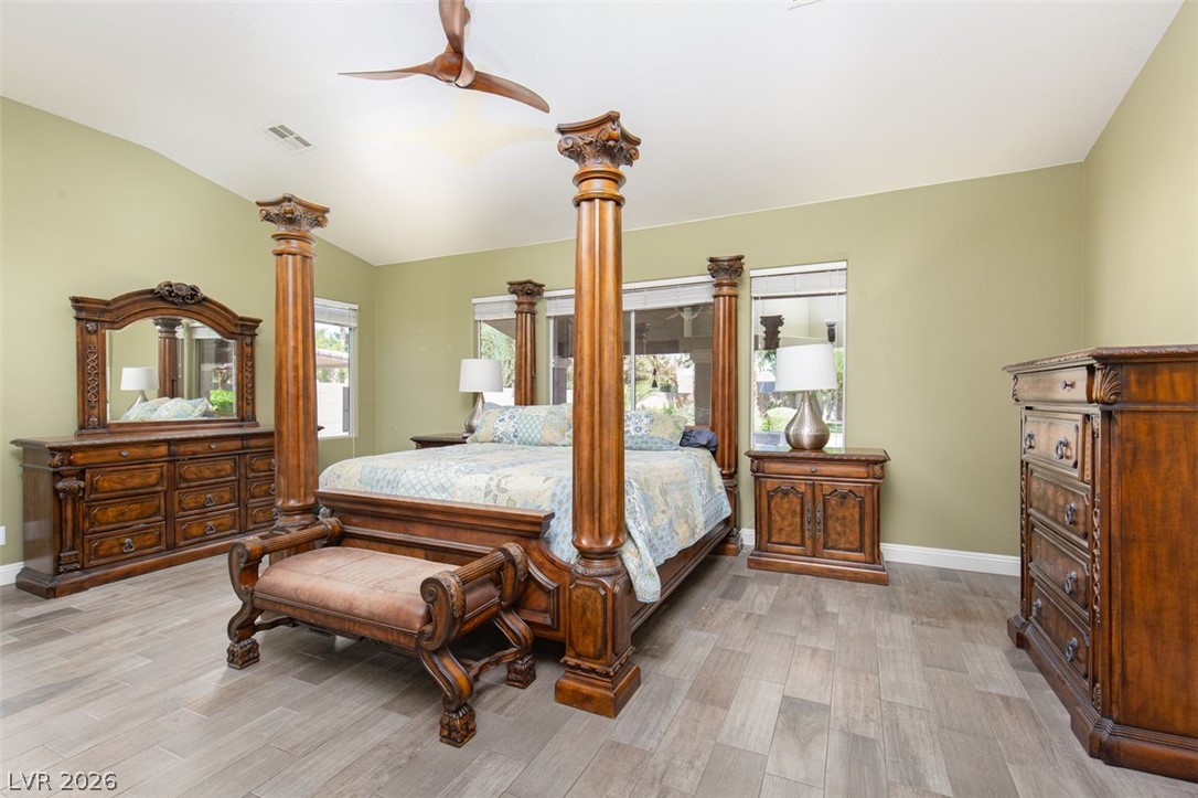 4670 Los Rancheros Avenue Las Vegas, NV 89129 - Photo 23 of 57 Vaulted ceilings and wood-look flooring enhance this spacious bedroom.