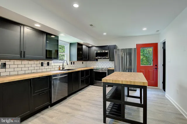 a kitchen with stainless steel appliances kitchen island granite countertop a sink counter space and cabinets