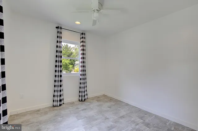 an empty room with windows and plants